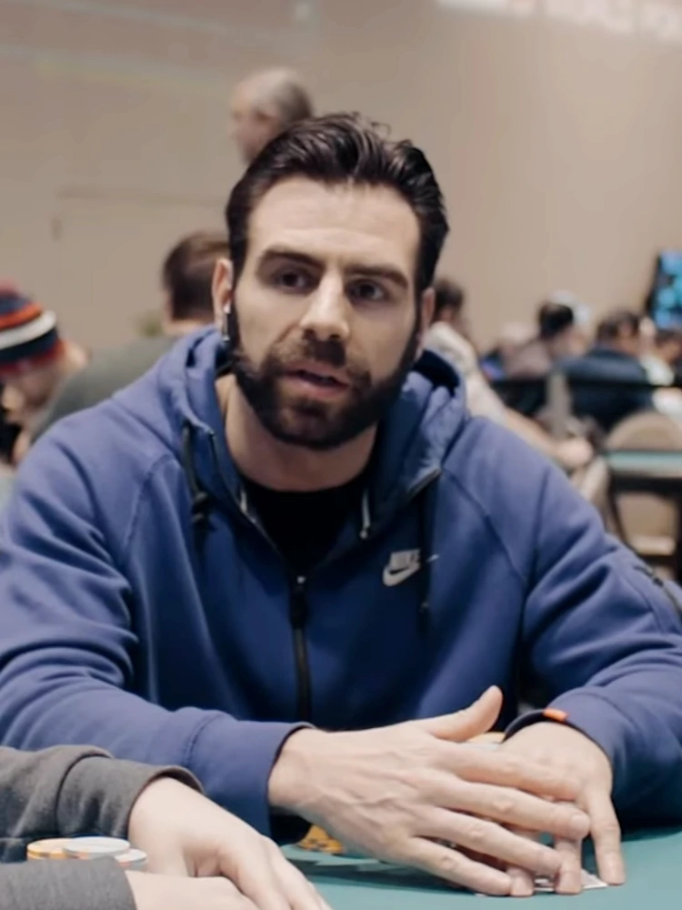 Olivier Busquet at a poker table in a blue hoodie