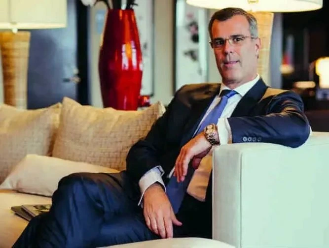 Olivier Chavy seated in a hotel lounge in a suit