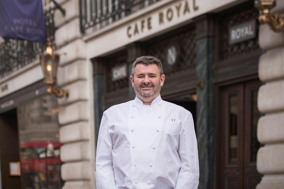 Laurent Tourondel standing outside Hotel Café Royal in a chef’s jacket